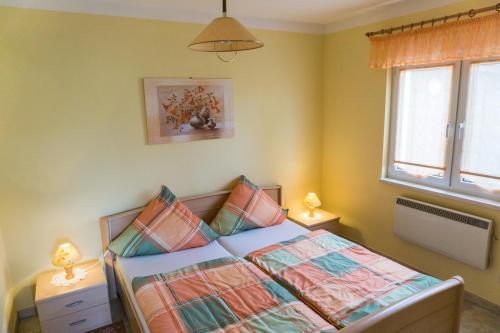 a bedroom with a bed with two lamps and a window at Ferienhaus Seensucht in Göhren-Lebbin