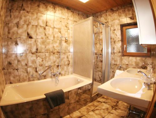 y baño con bañera y lavamanos. en The Seefeld Retreat - Central Family Friendly Chalet - Mountain Views, en Seefeld in Tirol