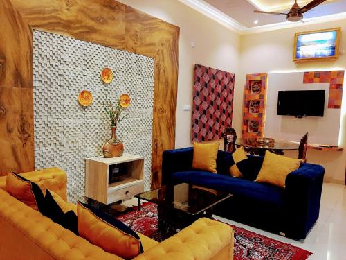 a living room with two couches and a tv at PANCHHI'S NEST Villa in Amritsar