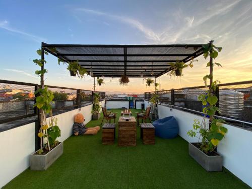 a balcony with a table and chairs on a roof at Backpack Hostel in Chiang Rai