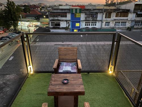 a bench on a balcony with a view of a city at Backpack Hostel in Chiang Rai