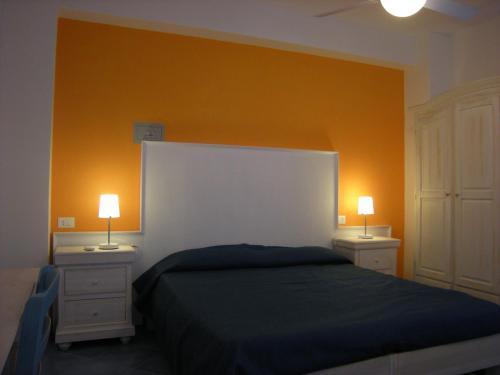a bedroom with a bed and two night stands with lamps at Residence Timeo in Ustica