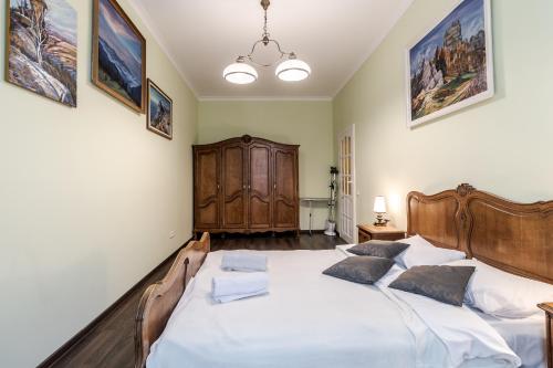 een slaapkamer met een groot bed met witte lakens bij Modern Chaikovskogo Apartment in Lviv