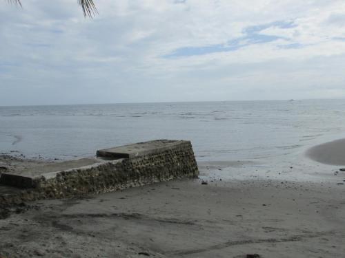 a stone wall on the beach near the ocean at Felipa Beach and Guesthouse - Gumamela in Dumaguete