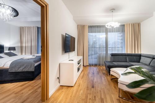 a living room with a bed and a couch at Seaside Park Private Apartment przy plaży in Kołobrzeg