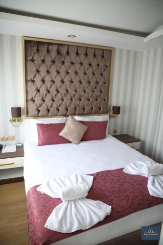 a bedroom with a large white bed with two towels at Burj Al Istanbul in Istanbul