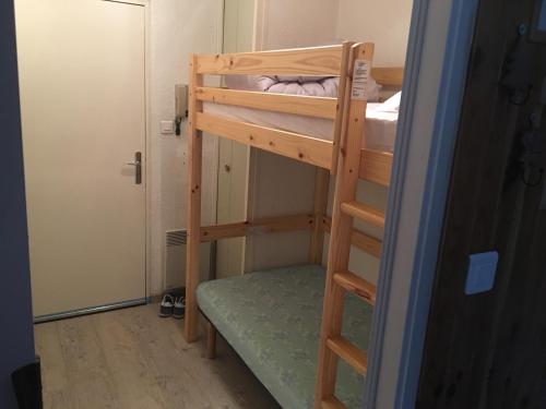 Cette chambre comprend 2 lits superposés et une porte. dans l'établissement Charmant studio, à La Bresse