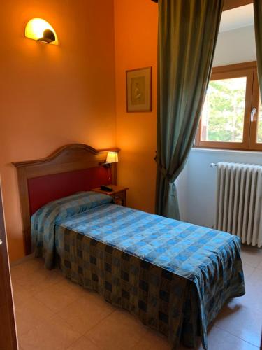 1 dormitorio con cama y ventana en Cristall Hotel en Rocca di Cambio