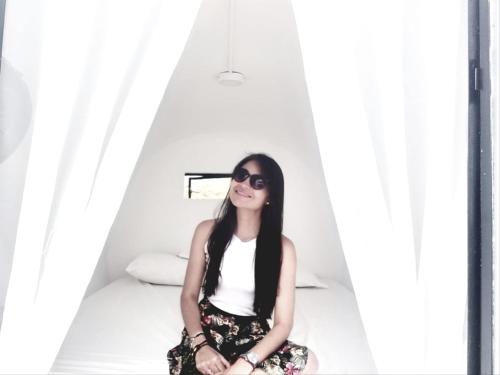 a woman sitting on a bed wearing sunglasses at Tubo Hotel La Tatacoa in Villavieja