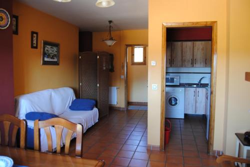 a living room with a couch and a kitchen at Casa Rural El Arranca in Riópar