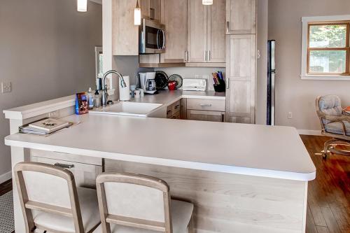 a kitchen with a white counter and two chairs at Fish on Rice Lake Waterfront Brainerd Cabin in Brainerd