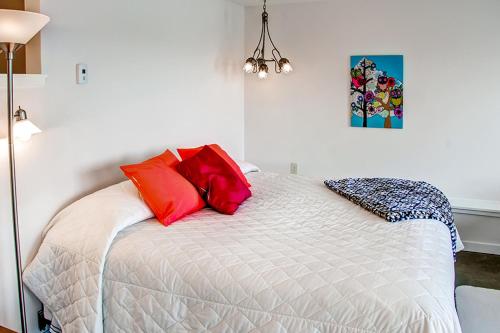 a bedroom with a bed with red pillows on it at Fish on Rice Lake Waterfront Brainerd Cabin in Brainerd