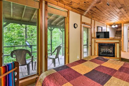 1 dormitorio con 1 cama y chimenea en Robbinsville Cabin with Deck 3 Mi to Fontana Lake! en Robbinsville