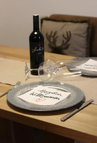 a plate with a napkin on a table with a bottle of wine at Ferienhaus Raich in Vandans