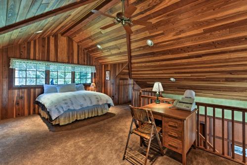 1 dormitorio en una cabaña de madera con cama y escritorio en Forested Gold Beach House with Panoramic Ocean Views!, en Ophir