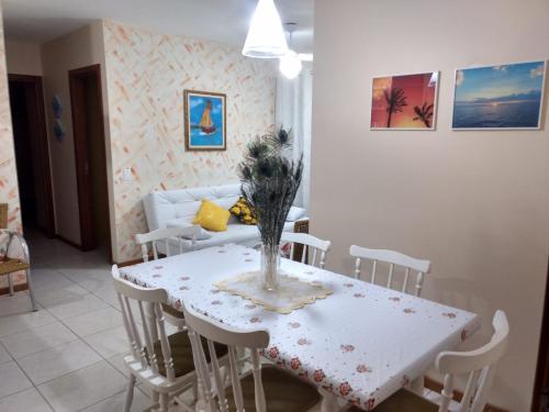 - une table et des chaises blanches dans le salon dans l'établissement Apartamento - Jd São Lourenço - Bertioga - Praia da Riviera, à Bertioga