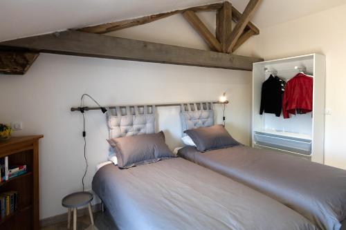 a bedroom with two beds and a mirror at Appartement La Haute Preze & Golffrance in Rouzède