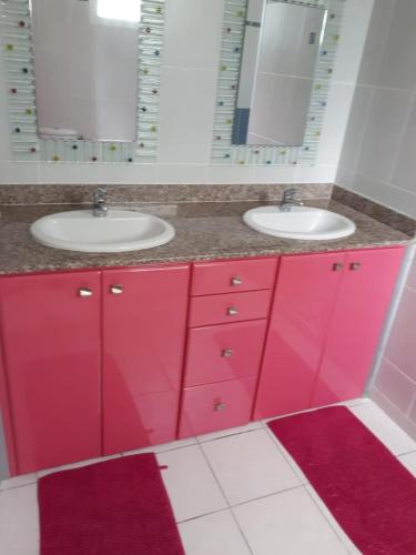 a bathroom with two sinks and red cabinets at Habitation du Château d'Ô - Vue sur Mer in Deshaies