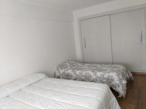1 dormitorio blanco con 1 cama y vestidor en Depto Centro MDP con Cochera, Wifi y Cable en Mar del Plata