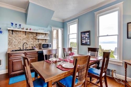 uma sala de jantar com uma mesa de madeira e cadeiras em Astoria Painted Lady Historic Apt with River View! em Astoria