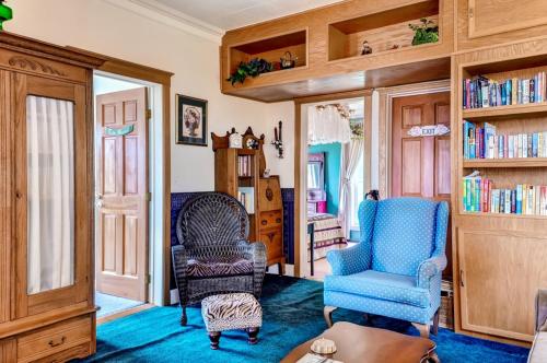 a living room with two chairs and a table at Astoria Painted Lady Historic Apt with River View! in Astoria, Oregon