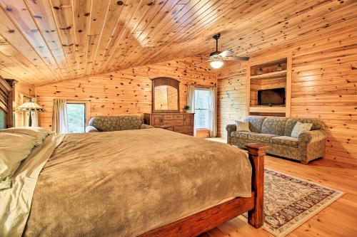 a bedroom with a bed and a couch and a tv at Lakefront Cabin with Private Deck, Dock and Fire Pit! in Nevis