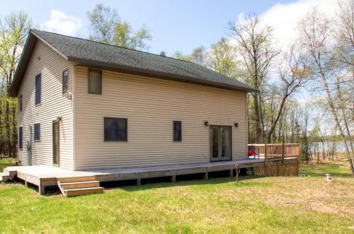 a large white house with a porch in a yard at Lakefront Cabin with Private Deck, Dock and Fire Pit! in Nevis