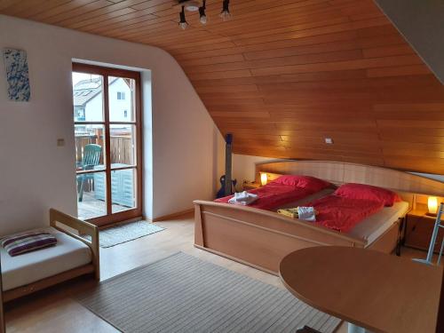 Un dormitorio con una cama con almohadas rojas y una mesa. en Villa Blue en Nördlingen