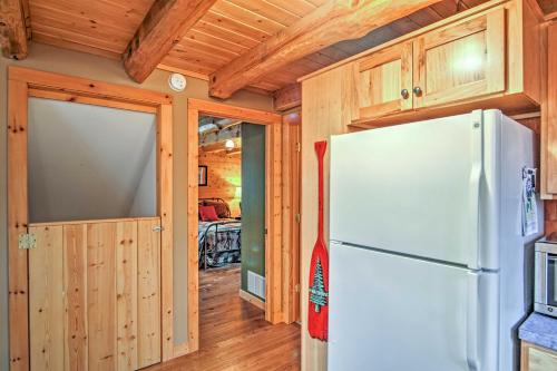 a kitchen with a refrigerator and a bedroom at Remote Pentwater Cabin in the Woods 5 Mi to Dtwn in Pentwater