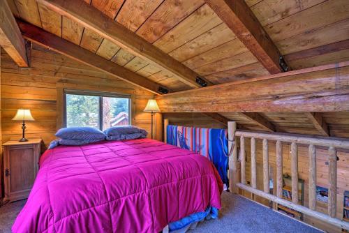 a bedroom with a pink bed in a cabin at Rustic Idaho Cabin Less Than 10 Mi to Payette Lake! in New Meadows
