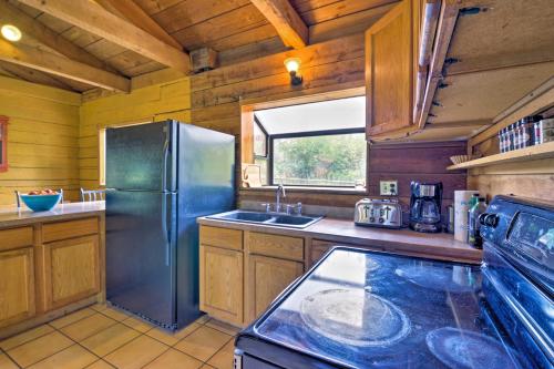 a kitchen with a stainless steel refrigerator and a sink at Rustic Idaho Cabin Less Than 10 Mi to Payette Lake! in New Meadows