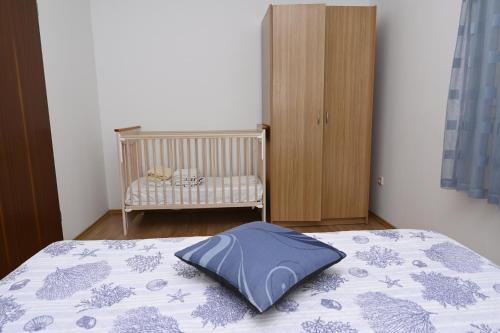 a bedroom with a bed with a blue pillow on it at Apartments "sea view" Miki & Ivana in Bol