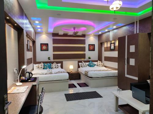 a room with two beds and a desk and a tv at HOTEL CENTRAL SQUARE "A Couple Friendly Hotel" in Muzaffarpur