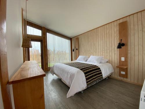 a bedroom with a large bed and a window at AKA Patagonia in Puerto Natales