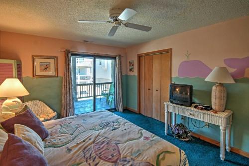 a bedroom with a bed and a television and a balcony at Kitty Hawk Townhome at Sea Dunes - Walk to Beach! in Kitty Hawk