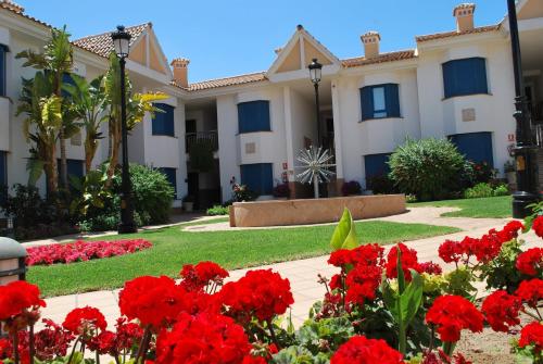 a house with red flowers in front of it at Hotel Golf Campoamor in Dehesa de Campoamor