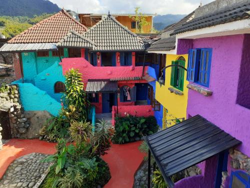 an image of a house painted in different colors at CasKaffeSu Hotel and Restaurant Mindo in Mindo