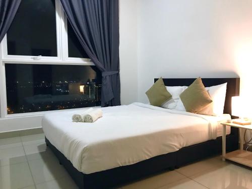 a bedroom with a large white bed with a window at Fabulous Mutiara Ville Cyberjaya in Cyberjaya