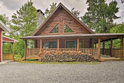 a log cabin with a pile of fire wood at Wraparound Deck Linville Mountain Cabin in Linville