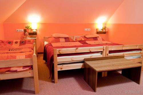 two twin beds in a room with orange walls at La Villa Pergola in Szentgotthárd