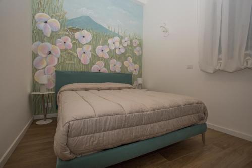 une chambre avec un lit avec un tableau sur le mur dans l'établissement La Casa di Nausicaa - Aurora, à Reggio de Calabre
