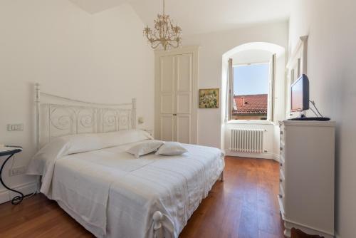 biała sypialnia z łóżkiem i oknem w obiekcie Vienna's house w mieście Lerici