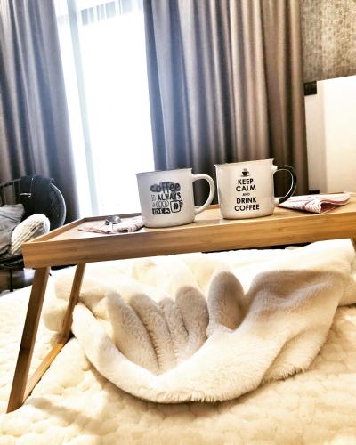 two coffee mugs sitting on a wooden table at Silver Mountain Milmari in Kopaonik