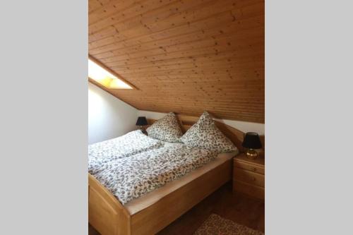 uma cama num quarto com tecto em madeira em Gästehaus Sansibar em Meinerzhagen