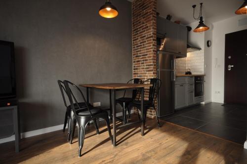 a kitchen with a table and chairs in a room at Schindler’s Factory Zabłocie Deluxe Apartments WAWELOFTS in Kraków