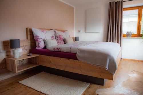 Schlafzimmer mit einem Bett mit rosa und weißen Kissen in der Unterkunft Ferienwohnung AlMa in Pflach