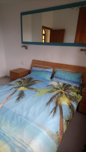 a bedroom with a bed with palm trees on it at fuerte blue in Costa Calma
