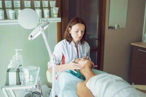 a woman in a hospital room performing a massage on a patient at Shepilska Relax Complex in Dovholuka