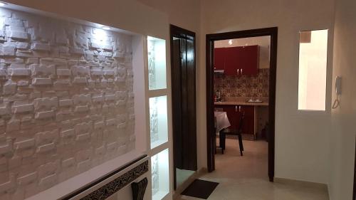 a hallway with a stone wall in a house at Appartement Plage Mehdia pour famille in Mehdiya-Plage