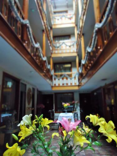 a table with yellow and pink flowers on it at Hotel San Francisco Plaza in Cusco